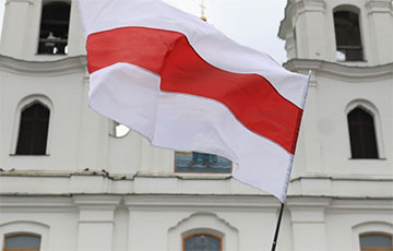 12 бело-красно-белых флагов развеваются на крыше дома в самом центре Минска